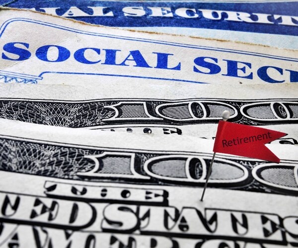 closeup of social security cards and money with retirement flag

