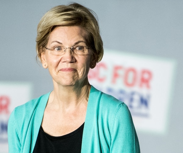 elizabeth warren stands on stage at a rally