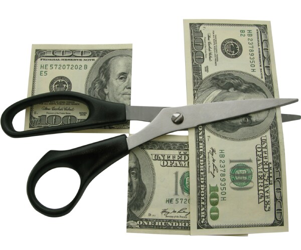 scissors cutting a hundred dollar bill