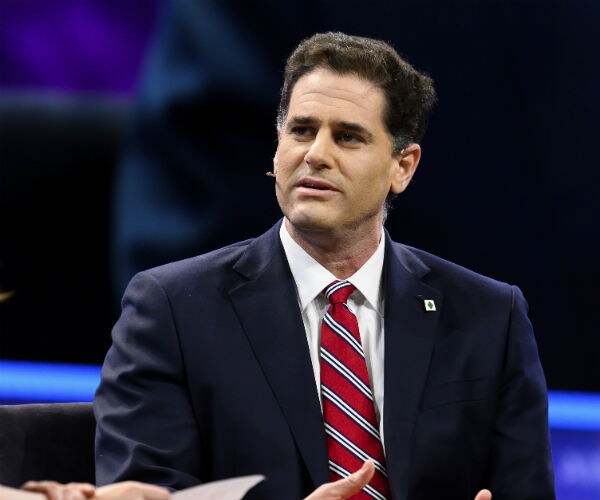 ron dermer is shown in a navy suit, red stripped tie and white dress shirt