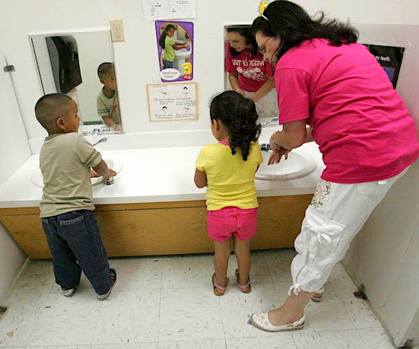 children at the texas migrant head start program wash their hands along side teacher aide arminda salinas.