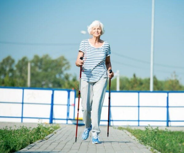 older woman walking with walking sticks