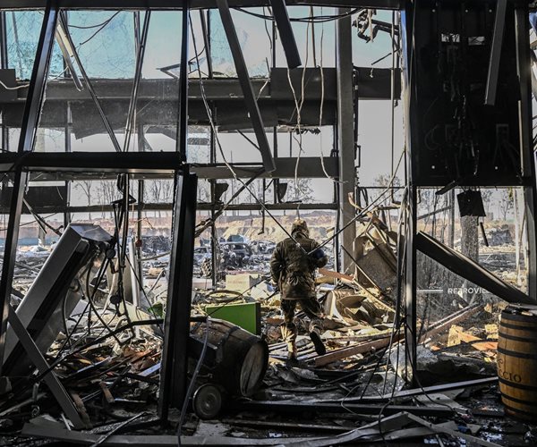 A Ukrainian serviceman walks between debris