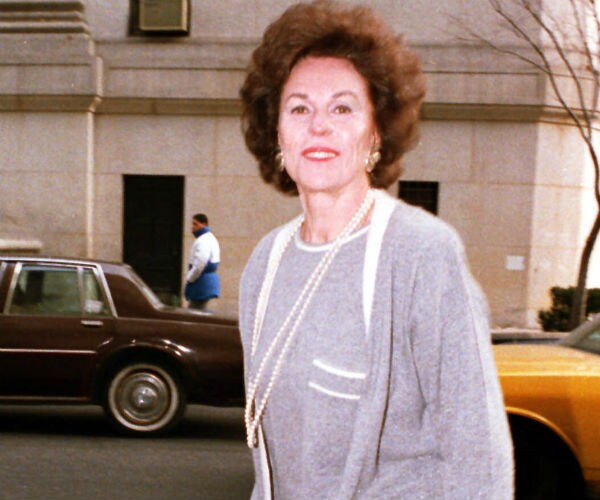 bess myerson is shown in a grey and white dress suit wearing pearls