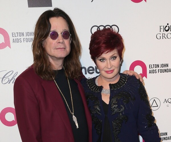 ozzy and sharon osbourne stand on red carpet