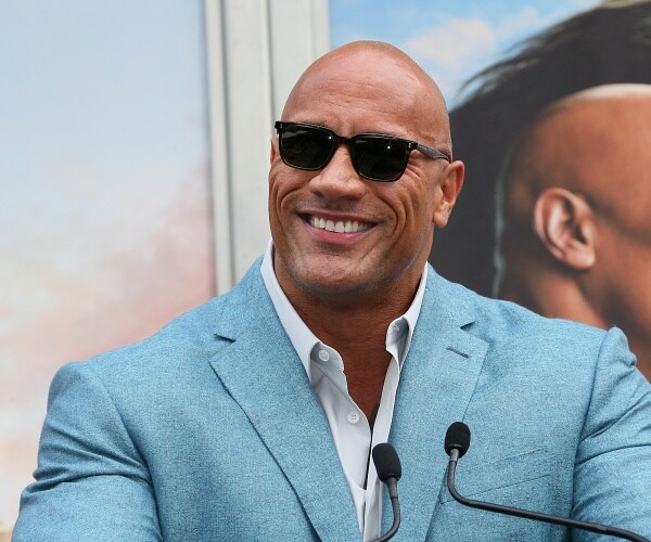 dwayne johnson speaks into mic