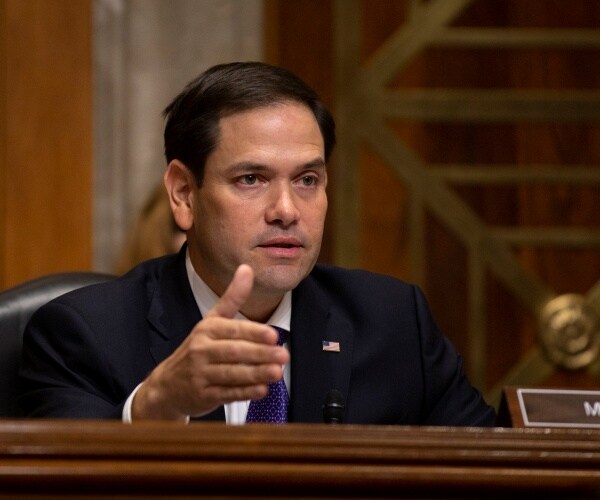 marco rubio in a suit and blue tie at a hearing