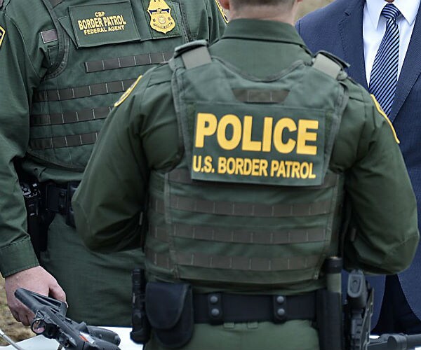 a border patrol officer speaking with other officials