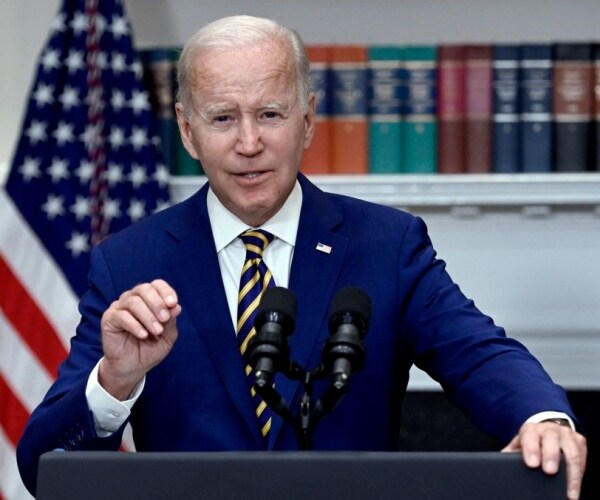 Joe Biden gestures while speaking into a microphone