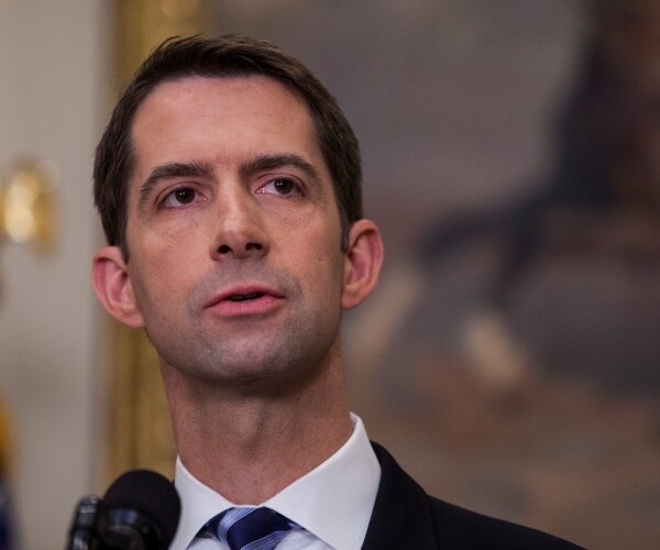 cotton in a blue striped tie and black suit speaking and looking up