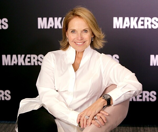 katie couric smiling wearing a white shirt and black pants