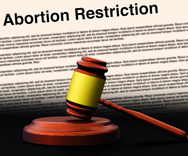 a document reading abortion restriction is in front of a judge's gavel in a photo illustration