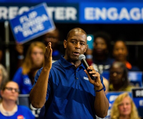 gillum in a blue polo shirt speaking at a voter registration event