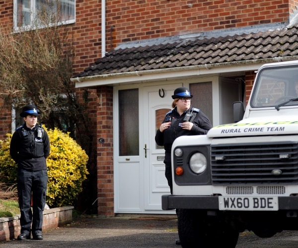 Police officers stand outside the house of former Russian double agent Sergei Skripal