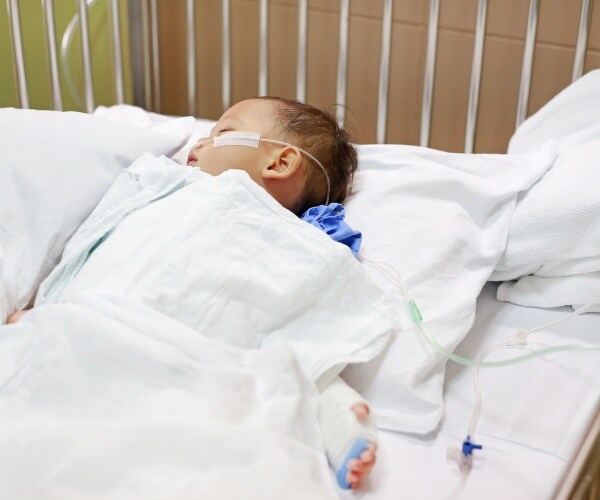 young child in hospital bed sleeping with oxygen in nose