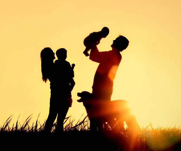 a family with a sunset in the background