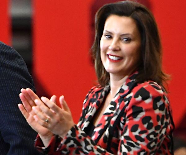 gretchen whitmer applauds during a meeting