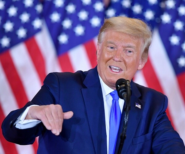 donald trump motions with hand behind podium