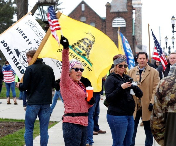 protesters wave american flags and gadsden flag outside of michigan capitol