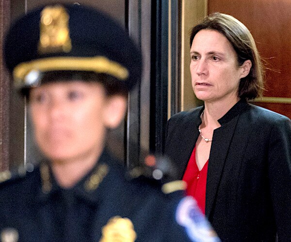 fiona hill walks out of a capitol hill secret meeting room behind a police officer