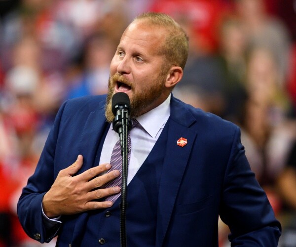 parscale in a navy blue suit and purple tie speaking at a trump rally