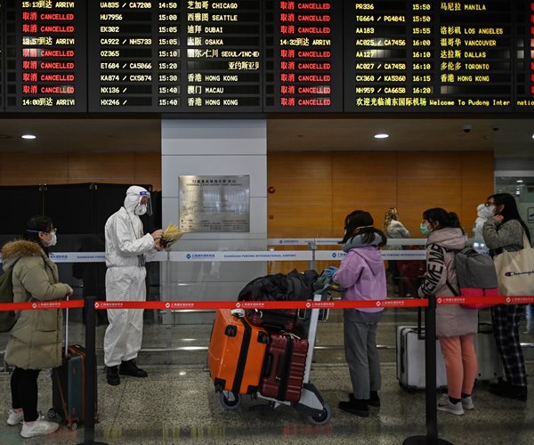 security officer in white hazmat suit at shanghai airport