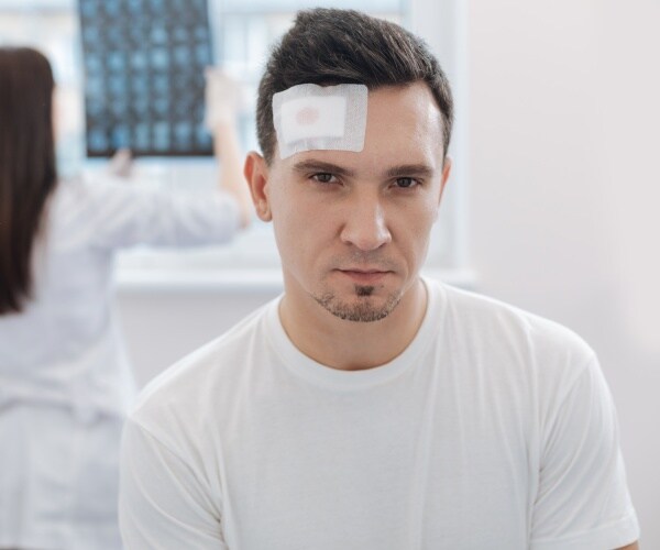 man with bandage on forehead