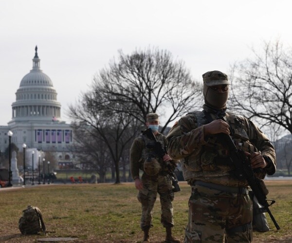 Members of the National Guard gather at the Capitol a day after the House impeached President Trump