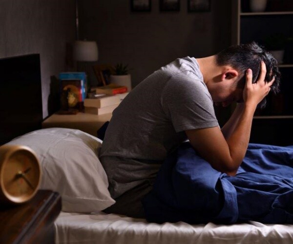 young adult having trouble sleeping in bed during night