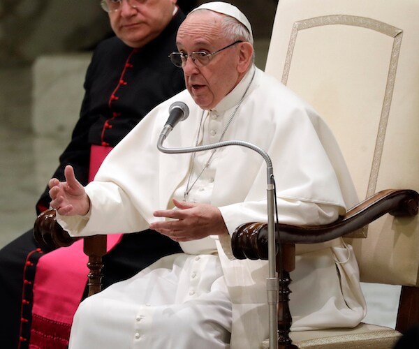 pope francis sits and speaks before a congregation