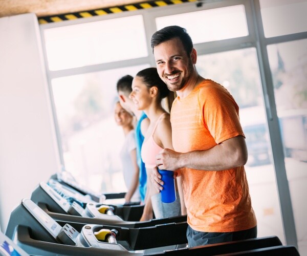 man on a treadmill, smiling at camera