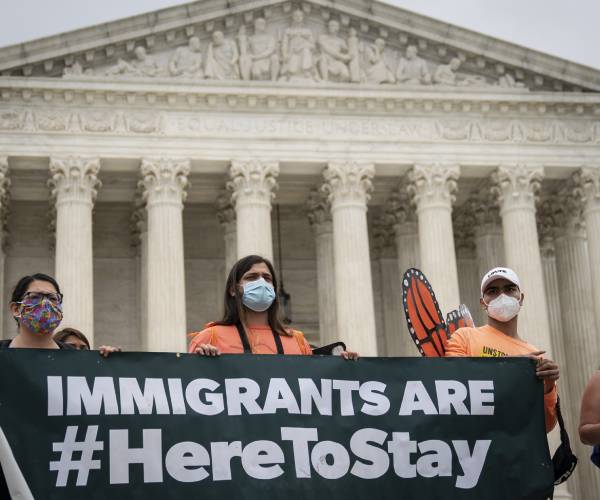 people with protest signs outside the supreme court building