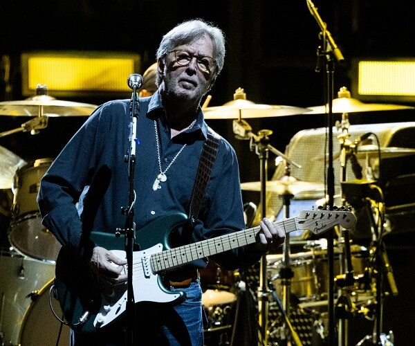 eric clapton plays guitar onstage