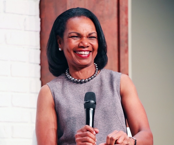 condoleeza rice smiles while holding mic