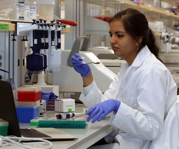 a researcher handles dna specimens in a scientific laboratory