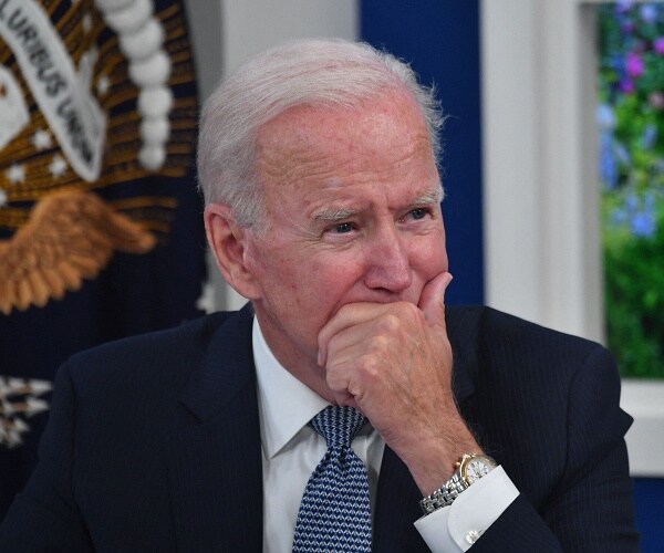 joe biden sits with chin resting on hand