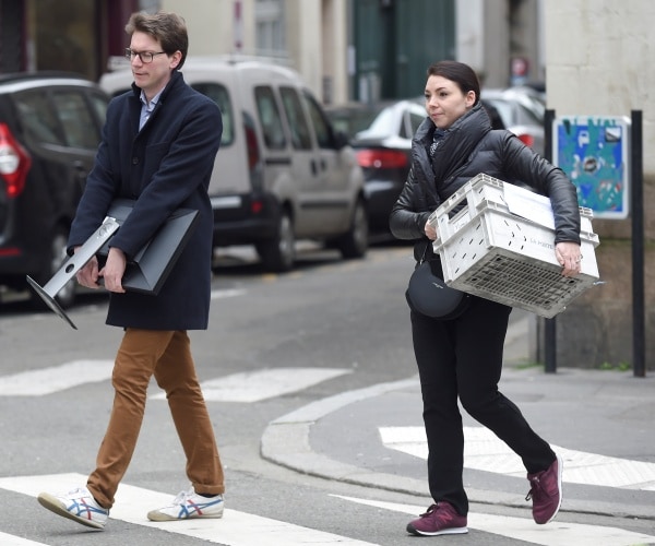 A man carries a computer monitor.