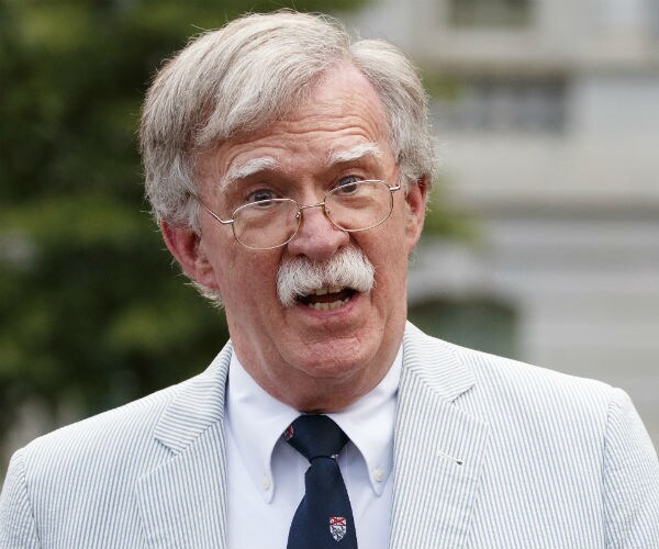 john bolton is shown wearing a light gray suit, dress shirt and tie