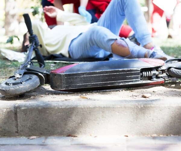 person and e-scooter on ground after accident