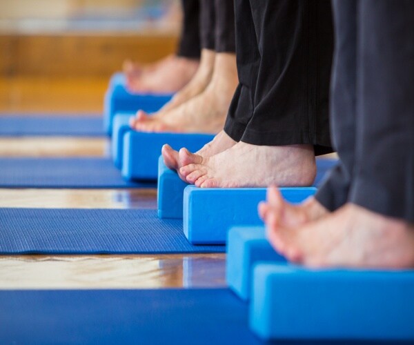 people standing on a raised mat barefoot