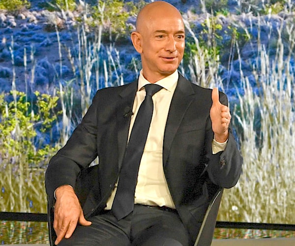 amazon founder jeff bezos sits and gives a thumbs up