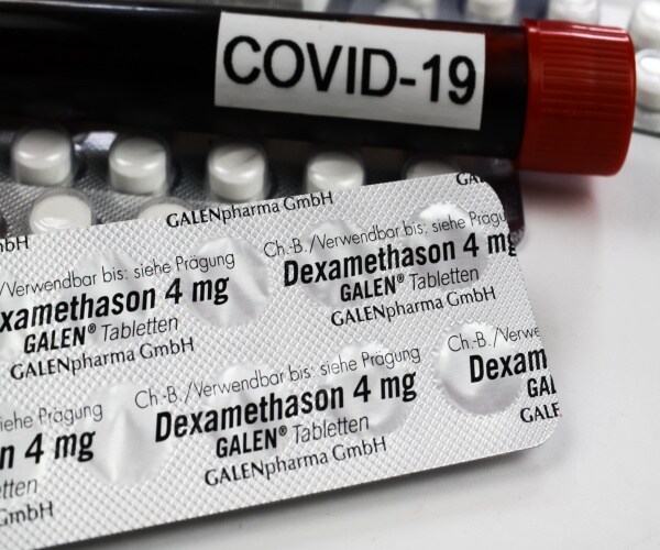 Vial labeled COVID and a blister pack of the medication dexamethasone