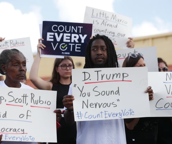 demonstrators hold up signs during a news conference in broward county, fla. 