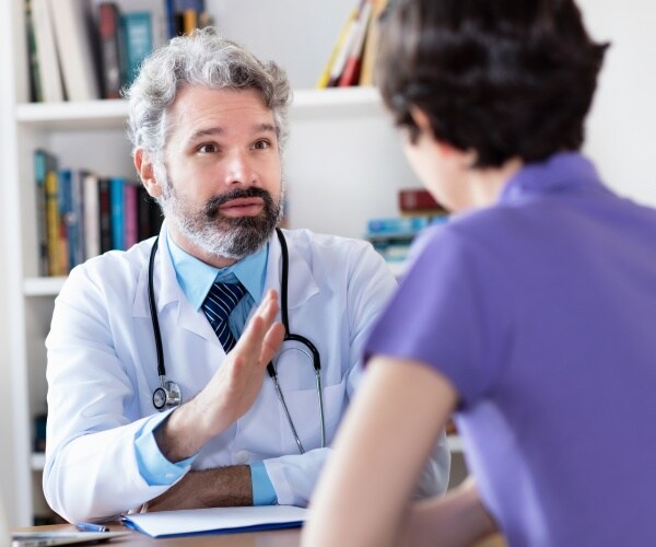 Mature doctor talking to patient.