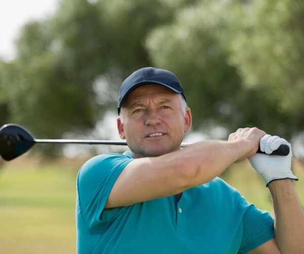 man hitting golf ball