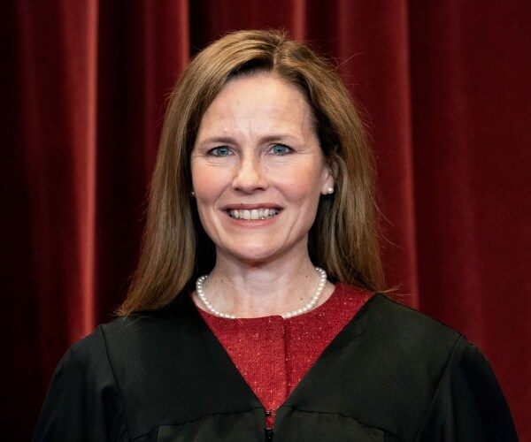 Justice Amy Coney Barrett stands during a group photo at the Supreme Court in Washington.