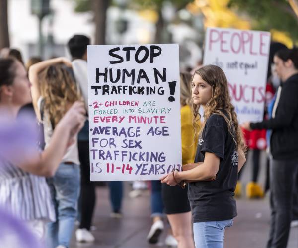 protesters against child trafficking hold signs