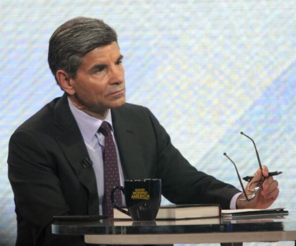 abc's george stephanopoulos is shown holding his glasses with a "good morning america" mug in front of him