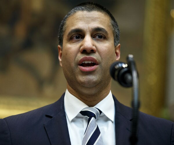 FCC Chairman Ajit Pai is shown speaking into a microphone