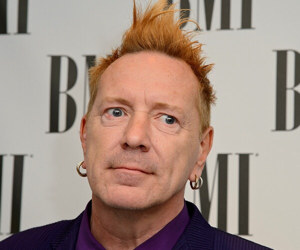 john lydon stands on red carpet